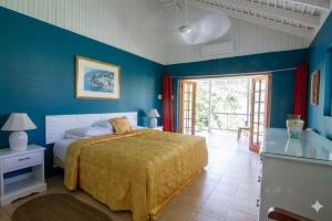 a bedroom with a bed and a blue wall at The Rocks Villa in Tower Isle