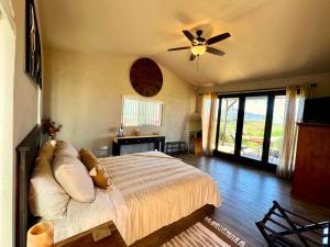a bedroom with a bed and a ceiling fan at The Bungalow @Terra Monarca in El Porvenir