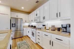 a kitchen with white cabinets and stainless steel appliances at Tranquil Desert Sanctuary in Indio +32 photos