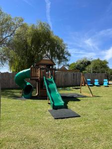 a playground with a slide and a play structure at Cabane Pod1 in Domfront-en-Champagne