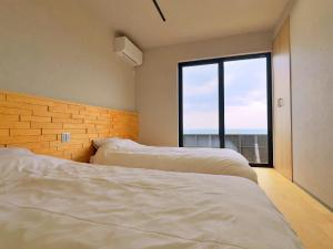 two beds in a bedroom with a large window at Private Villa 蒼 Lala & Lino in Kyotango +60 photos