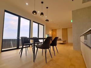 a dining room with a table and chairs and windows at Private Villa 蒼 Lala & Lino in Kyotango