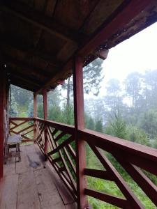 eine Veranda einer Hütte mit einer Bank darauf in der Unterkunft Bosque de Niebla in Tlatlauquitepec
