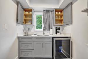 a kitchen with white cabinets and a window at Ocean Blvd Two Doubles Suite with Kitchenette in Fort Lauderdale