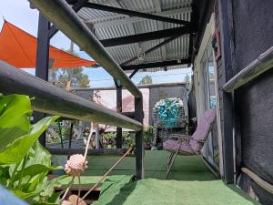 a patio with an umbrella and a chair at Mini Regugio in Chillán