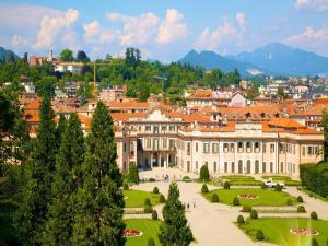 a large building with a garden in front of a city at Spacious Apartment near Lake Maggiore in Luino