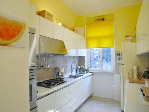 a kitchen with yellow walls and white cabinets at Spacious Apartment near Lake Maggiore in Luino +22 photos