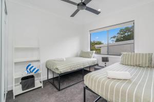 a bedroom with two beds and a window at Bay Breeze Beachhouse in Scarness +29 photos