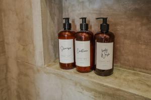 three bottles of alcohol are sitting on a shelf at Simple Stay, Big Views, Private Room & Pool in Todos Santos