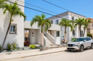 a car parked in front of a house with palm trees at The Madison by the Gold Nests in Hollywood