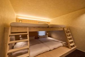 a bunk bed in a small room with two bunk beds at 開土 KAIDO Hotel in Sapporo +94 photos