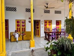a man sitting on a couch in a room with a table at Casa de Luna in La Dorada