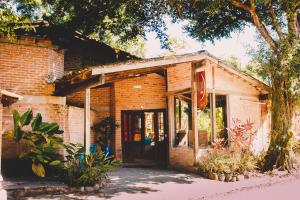 an old brick house with a large glass door at Alua Camburi in Camburi