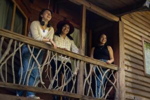 Eine Gruppe von drei Frauen steht auf der Veranda eines Hauses. in der Unterkunft Bosque de Niebla in Tlatlauquitepec + 29 Fotos