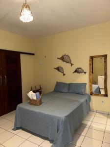 a bedroom with a bed with three fish on the wall at Rota do Mar in Luis Correia