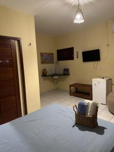 a room with a bed and a television and a couch at Rota do Mar in Luis Correia