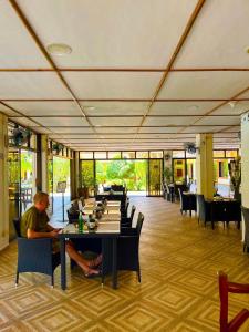 a man sitting at a table in a restaurant at Sunville Hotel and Restaurant in Panglao Island