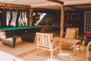a room with a pool table and two chairs at Alua Camburi in Camburi