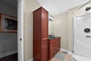 a bathroom with a wooden cabinet and a sink at Baltimore premier townhouse in Baltimore +21 photos