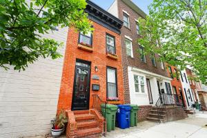 a brick house with trash cans in front of it at Baltimore premier townhouse in Baltimore