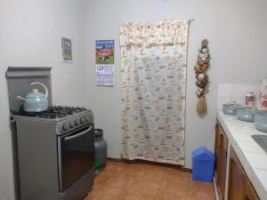 a kitchen with a stove and a shower curtain at Depa Huancayo in Huancayo