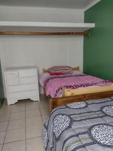 two beds in a room with a dresser and a bed sidx sidx sidx sidx at Depa Huancayo in Huancayo