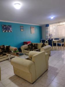 a living room with couches and tables and blue walls at Depa Huancayo in Huancayo