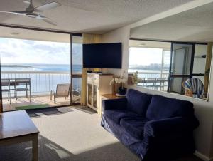 a living room with a couch and a view of the ocean at Gemini Unit 64 Golden Beach QLD in Golden Beach