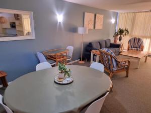 a living room with a table and chairs and a couch at Gemini Unit 64 Golden Beach QLD in Golden Beach