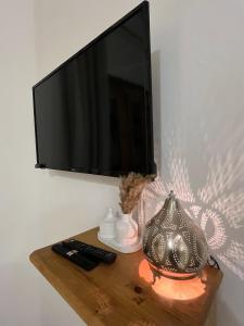 a television on a wall with a table with a lamp at Oia seafront house in Dahab