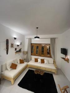 a living room with two white couches and a window at Oia seafront house in Dahab