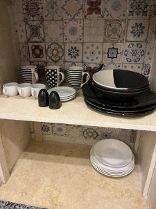 a shelf with plates and cups and dishes on it at Oia seafront house in Dahab +47 photos