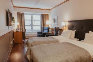 a hotel room with two beds and a chair at Home Hotel With in Tromsø +35 photos