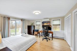 a bedroom with a bed and a desk with a computer at 3 Bedroom Cape House by Leavetown Vacations in Sandwich