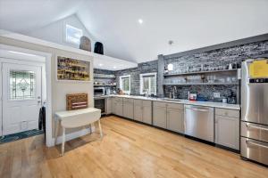 a kitchen with stainless steel appliances and a brick wall at 3 Bedroom Cape House by Leavetown Vacations in Sandwich