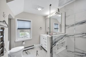 a white bathroom with a shower and a toilet at 3 Bedroom Cape House by Leavetown Vacations in Sandwich +35 photos