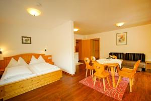 a bedroom with a bed and a table and chairs at Haus Hubertus in Wagrain