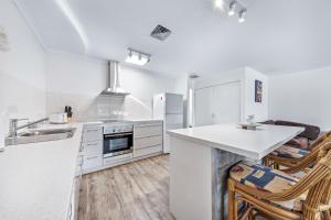 a kitchen with white appliances and a counter top at Blue Lagoon Airlie Beach in Airlie Beach