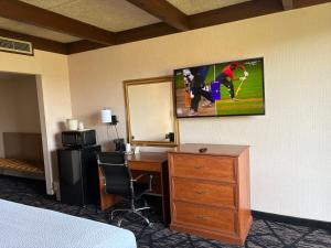 a hotel room with a desk and a tv on the wall at Days Inn by Wyndham Niles in Niles