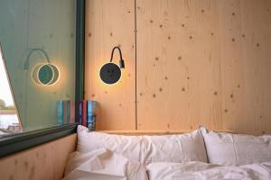 a bedroom with wooden walls and a bed with white pillows at Tiny House Nook 2 - Green&Tiny Hideaway Eider in Süderstapel