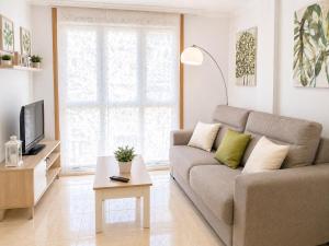 a living room with a couch and a tv at APARTAMENTO SOL in Viveiro