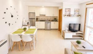 a kitchen with a table and chairs and a television at APARTAMENTO SOL in Viveiro