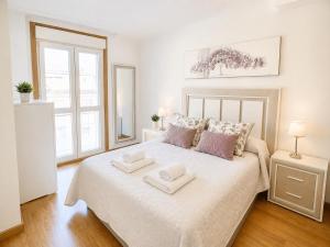 a bedroom with a large bed with two towels on it at APARTAMENTO SOL in Viveiro