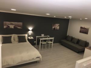 ナポリにあるThe Lux B&B Napoli Mergellinaのベッドルーム1室(ベッド1台、テーブル、ソファ付)