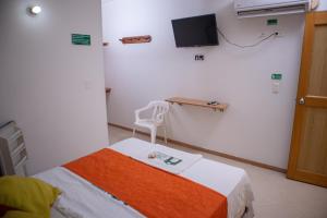 a hospital room with a bed and a tv on the wall at Hotel BENNY Los Leones Melgar in Melgar