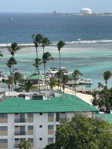 a building on the beach with palm trees and the ocean at Little friend #1 Two balconies,elevator in Boca Chica
