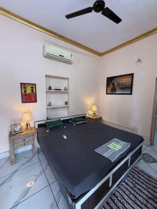 a room with a bed with a ceiling fan at Sariska Haveli in Alwar