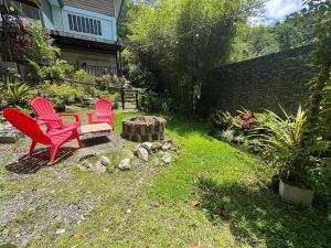 two red chairs and a table in a yard at Cloudrest Marilog in Kayagan
