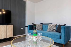 a living room with a blue couch and two wine glasses at Spacious 3BR Durham Home Contractor Friendly in Durham