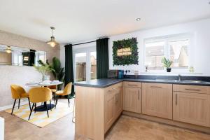 a kitchen with a table and a dining room at Stylish Durham 3-Bed Comfort Long Stays in Spennymoor